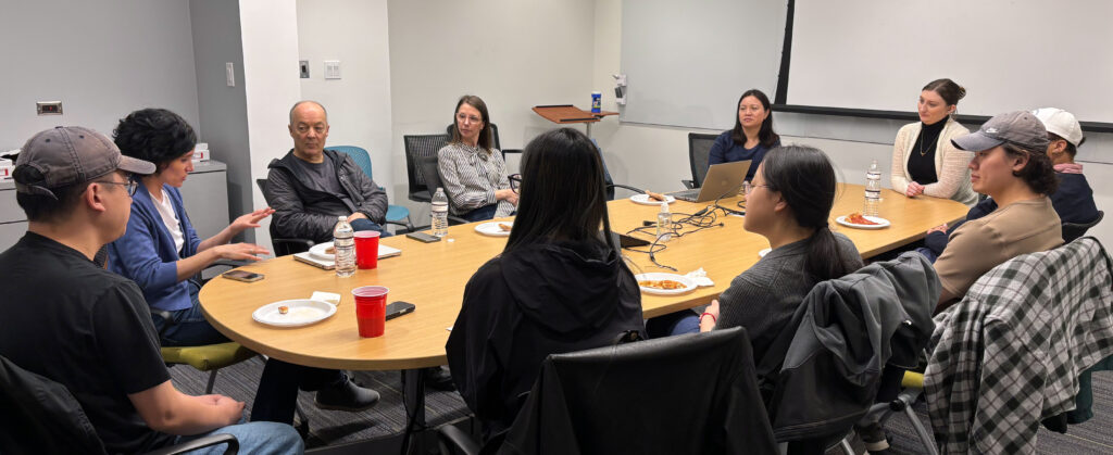 group of students and faculty sitting around a conference room table